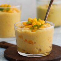 yellow colored mango pudding in a glass jar.