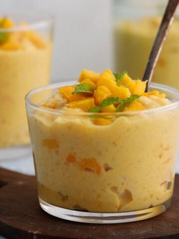 yellow colored mango pudding in a glass jar.