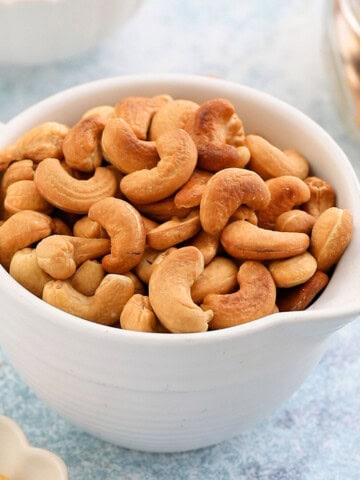 roasted cashew nuts in a white bowl.