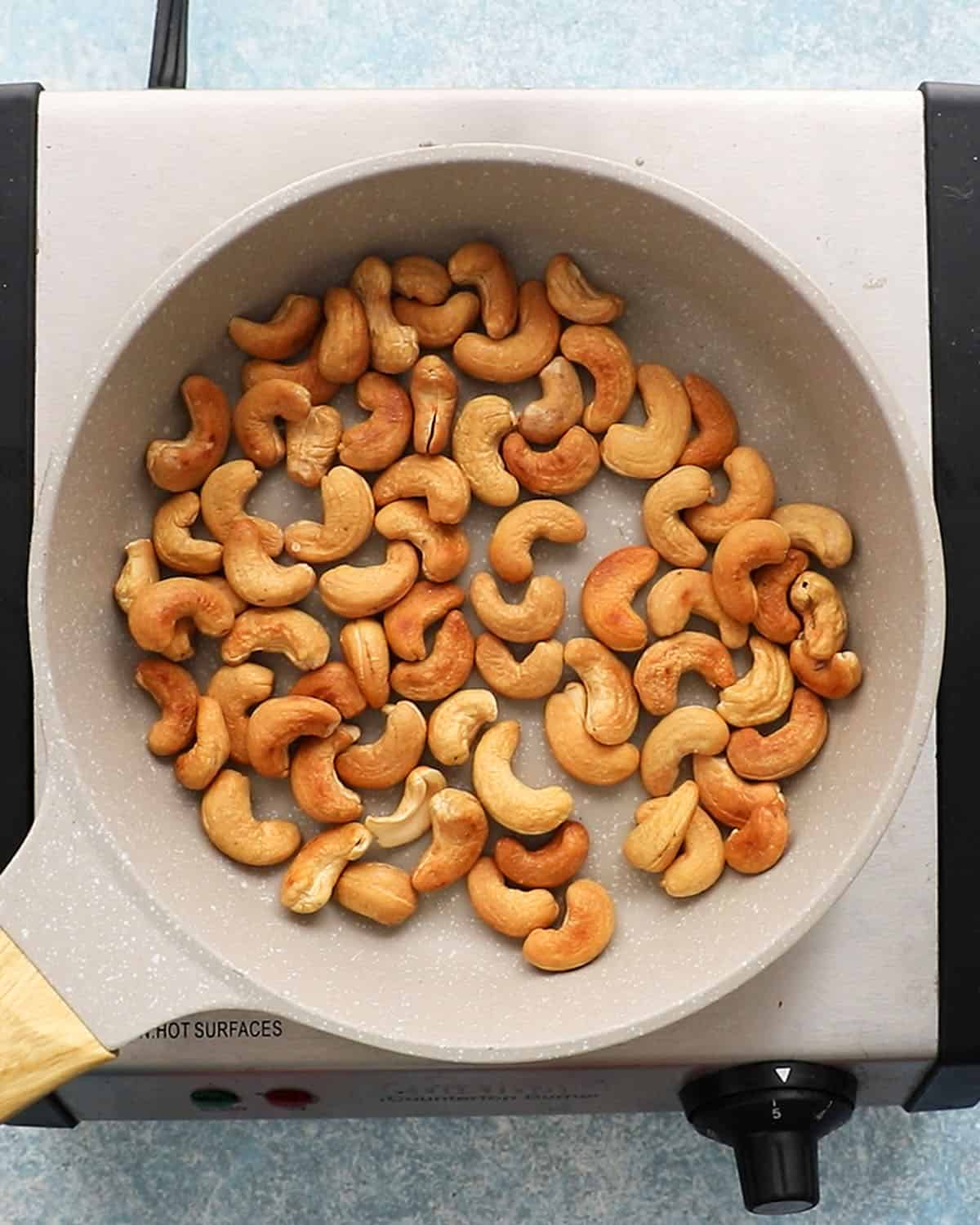 roasted cashews in a small white skillet.