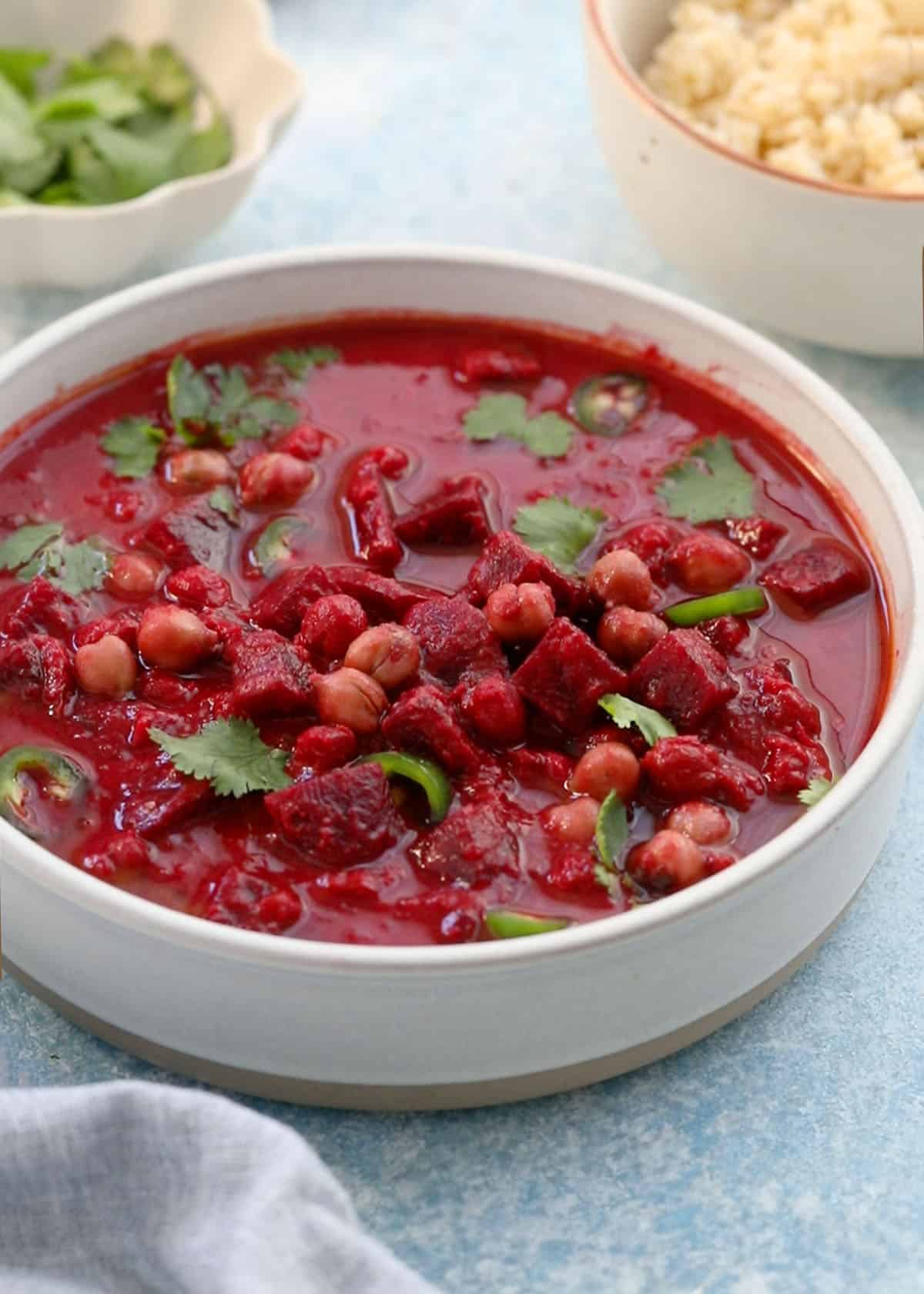 pink colored beet curry in a large white bowl.