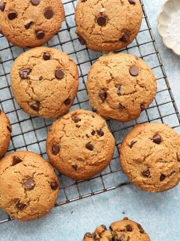 12 almond flour chocolate chip cookies placed on a metal wire rack.