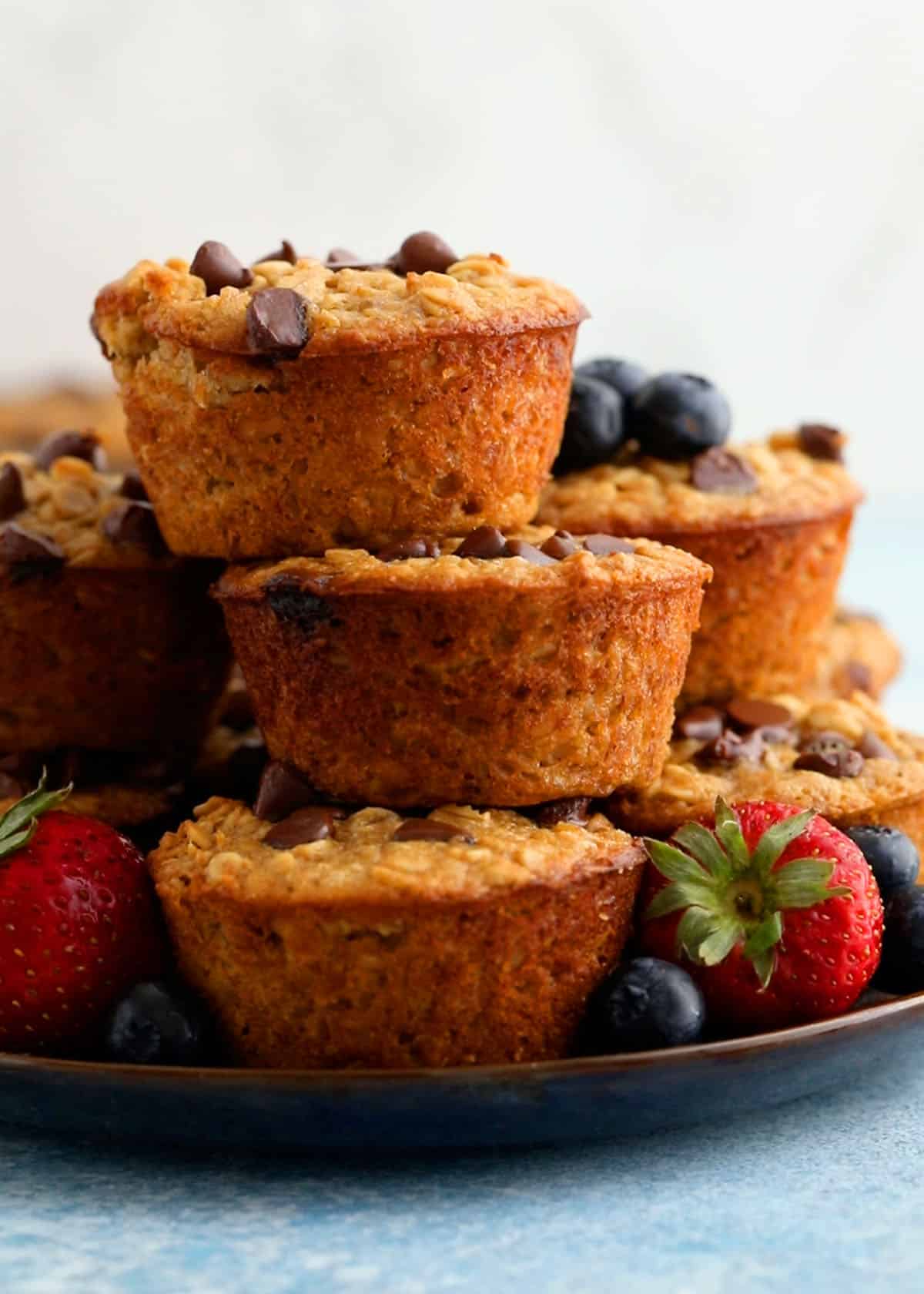 5 oatmeal cup muffins piled high on a plate.