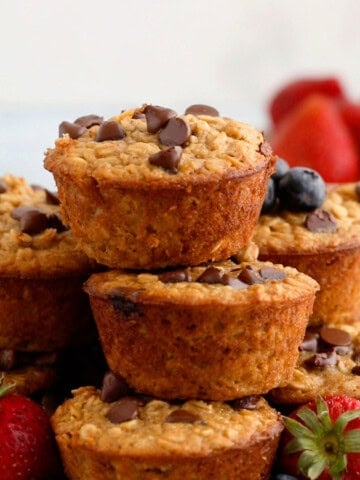 5 oatmeal cup muffins piled high on a plate.