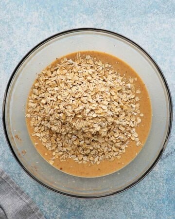 rolled oats along with brown liquid in a large glass bowl.