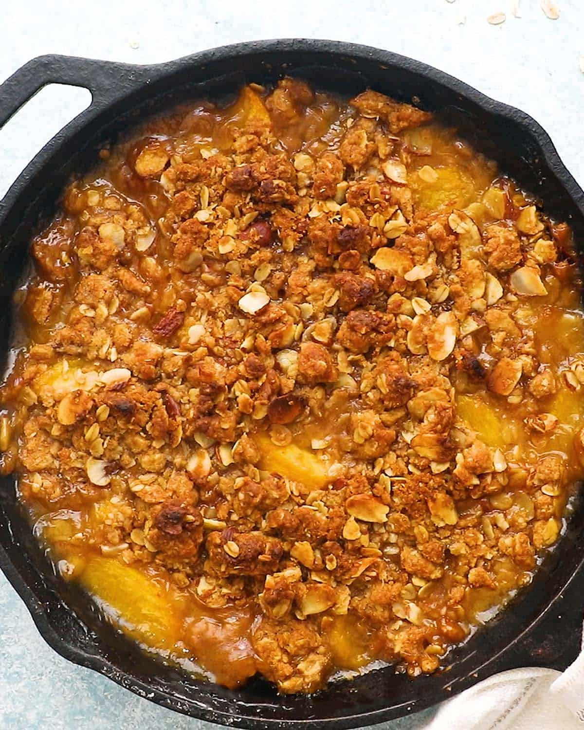 baked peach crumble in a black skillet.