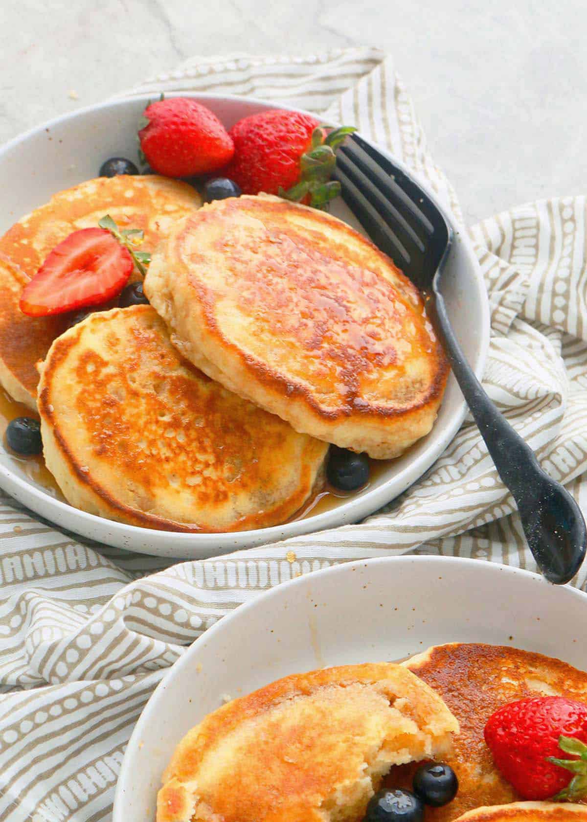 two white plate with three cooked pancakes in each.