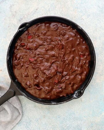 chocolate brownie batter in a black skillet.