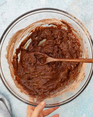 chocolate zucchini muffin batter placed in a glass bowl.