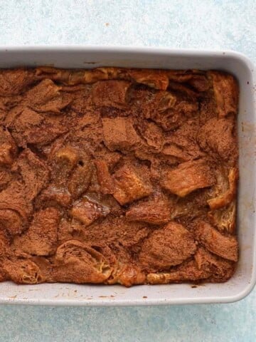 baked croissant bread pudding in a grey baking pan.