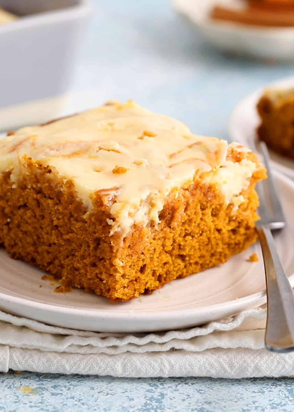 one square slice of pumpkin cake on a white plate.