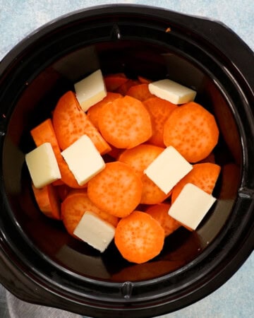 sliced sweet potatoes and white butter placed in a black pot.